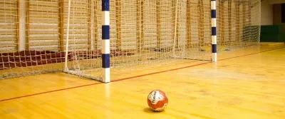 Här kommer den danska översättningen av texten: Sådan forebygger du ankelskader i indendørssport – effektive tips & beskyttelse Billede af en håndbold på en håndboldbane
