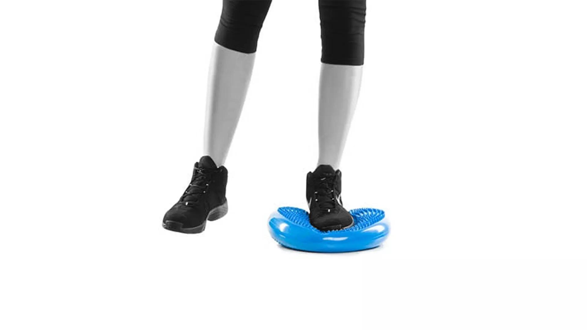 Øvelse 8. Etbensstående på balancepude Person, der står med et ben på en balancepude